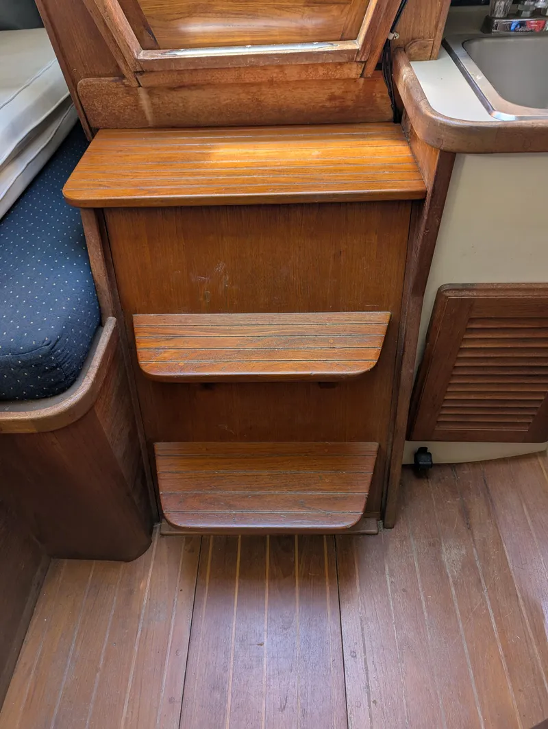 Slide: The Image of Wooden interior steps on 1984 Islander 28 sailboat, featuring polished finish and compact design. - 17