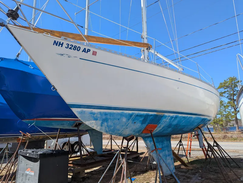 Slide: The Image of 1984 Islander 28 sailboat on stands, hull number NH 3280 AP, in a boatyard. - 3