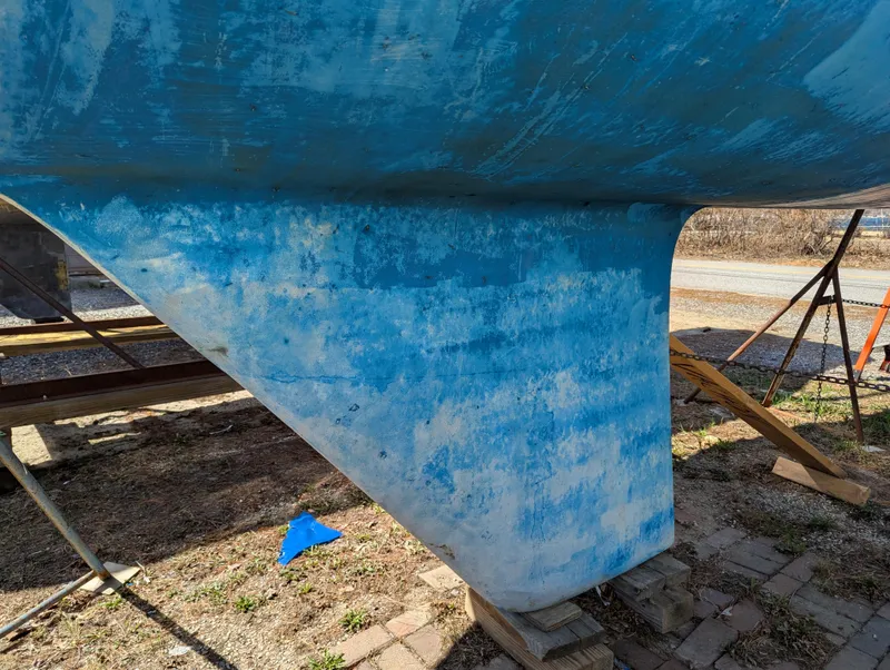 Slide: The Image of Close-up of a 1984 Islander 28 sailboat keel, showing weathered blue paint. - 4