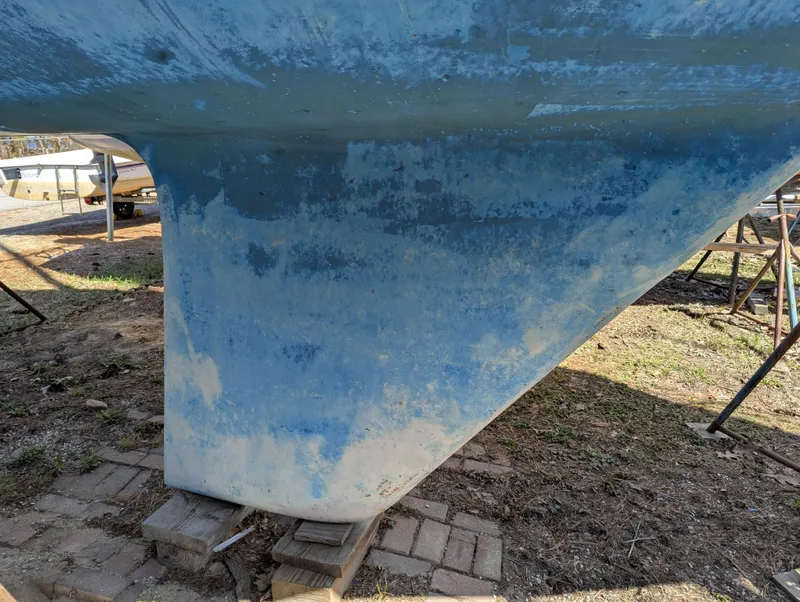 Slide: The Image of 1984 Islander 28 sailboat keel on dry land, showing weathered blue paint. - 5