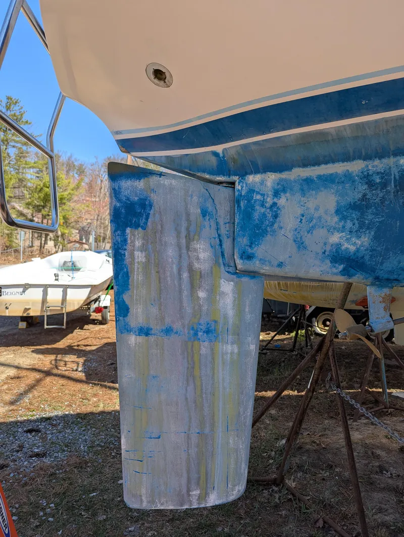 Slide: The Image of 1984 Islander 28 sailboat hull with weathered blue paint, on dry dock. - 6