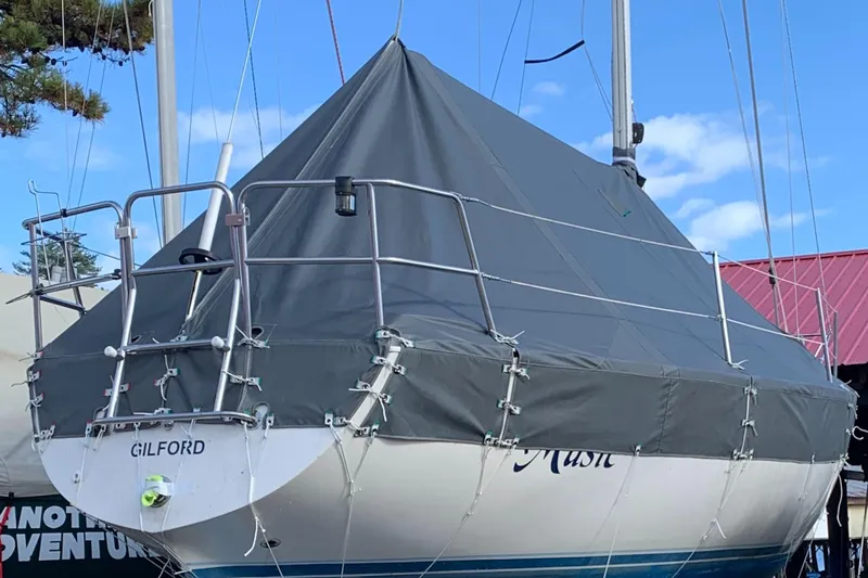 Slide: The Image of 1984 Islander 28 sailboat with protective cover, docked outdoors. - 7