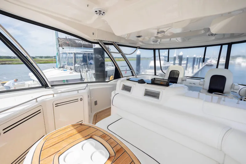 Slide: The Image of Interior of 2008 Sea Ray 58 Sedan Bridge yacht with white seating and wooden table. - 22