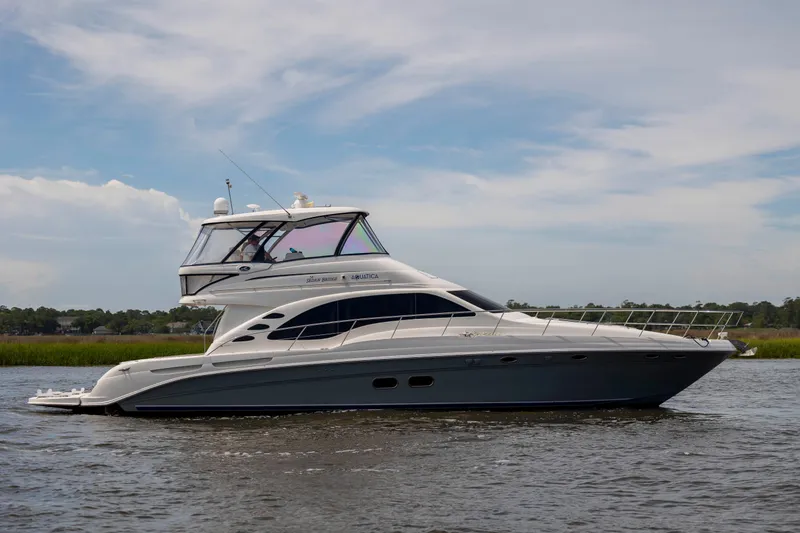 Slide: The Image of 2008 Sea Ray 58 Sedan Bridge yacht cruising on calm waters under a clear sky. - 9