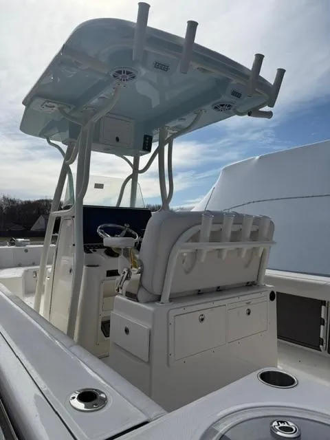 Slide: The Image of 2025 Sea Born LX24 Center Console boat with T-top and seating, viewed from the rear. - 1