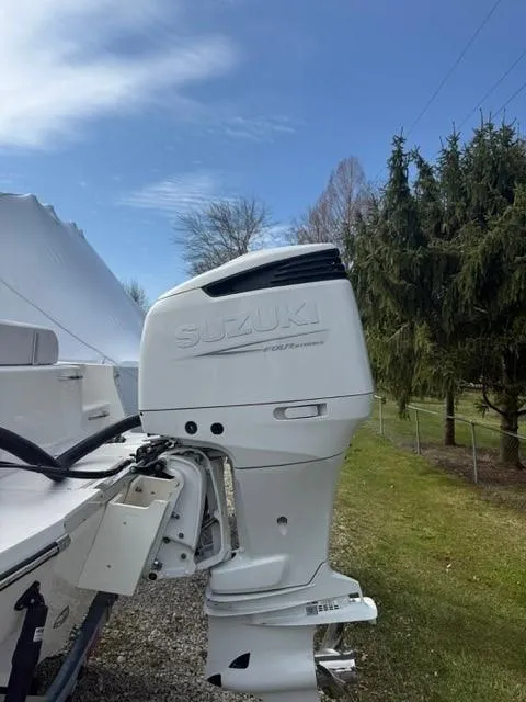 Slide: The Image of 2025 Sea Born LX24 Center Console with Suzuki outboard motor, parked outdoors. - 23