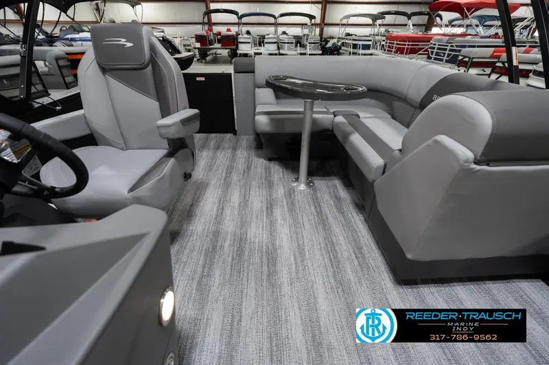 Slide: The Image of 2025 Bennington 21 SLJ boat interior with gray seating and table, showcased by Reeder-Trausch Marine. - 18