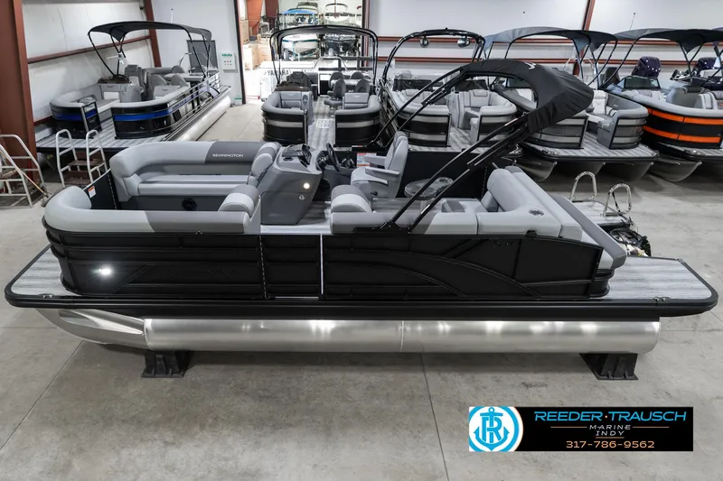 Slide: The Image of 2025 Bennington 21 SLJ pontoon boat in showroom, side view, sleek black design. - 2