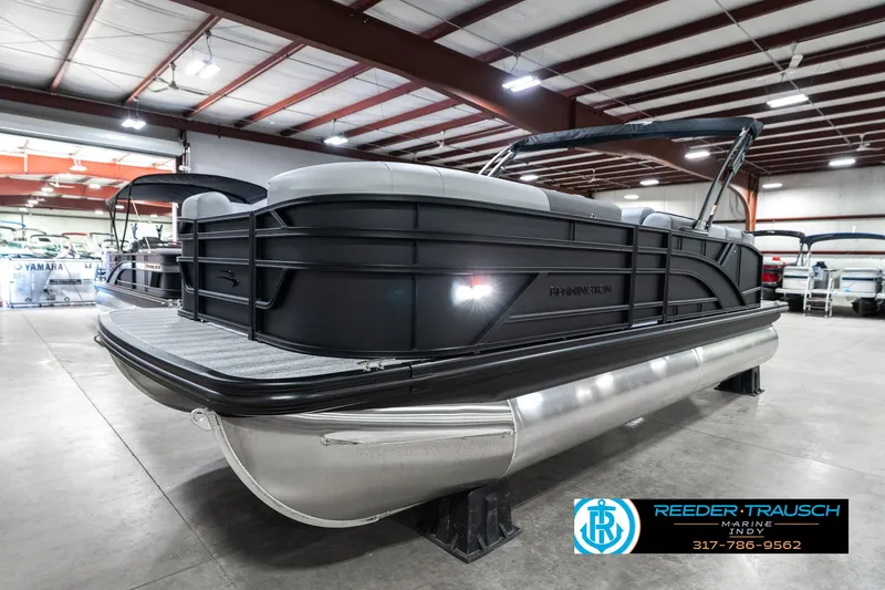 Slide: The Image of 2025 Bennington 21 SLJ pontoon boat in showroom, sleek design, black exterior. - 3