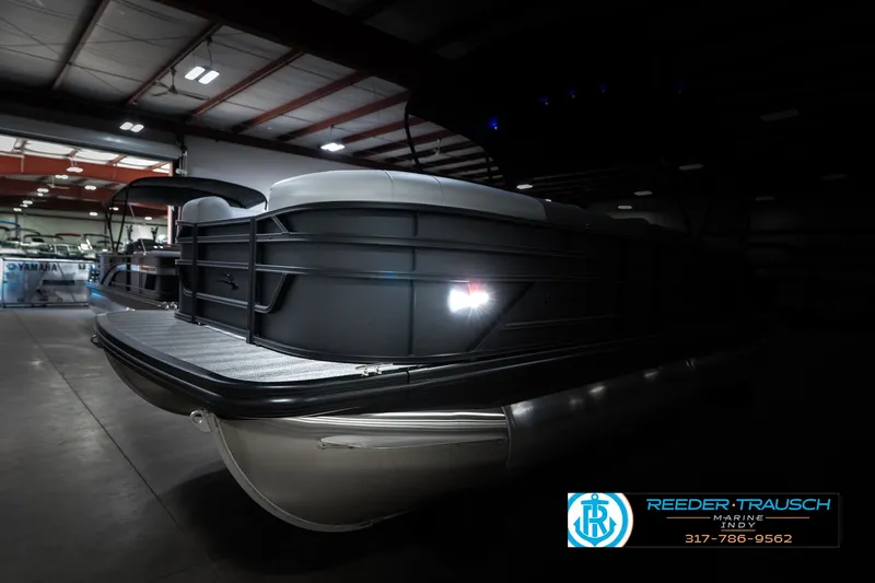 Slide: The Image of 2025 Bennington 21 SLJ pontoon boat in a dimly lit showroom. - 5