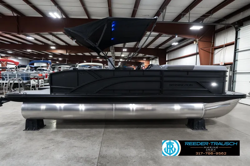 Slide: The Image of 2025 Bennington 21 SLJ pontoon boat in showroom with black canopy. - 8