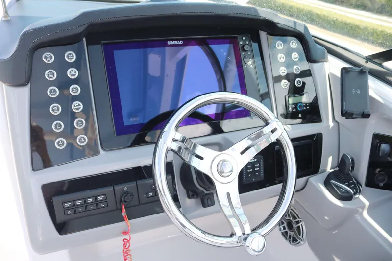 Slide: The Image of 2023 Robalo R317 boat dashboard with steering wheel and navigation display. - 12