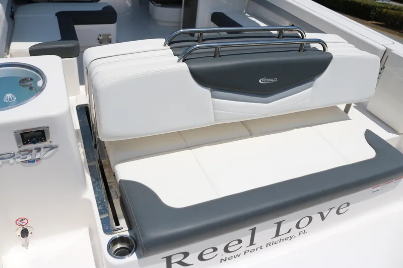 Slide: The Image of 2023 Robalo R317 boat interior with seating, labeled "Reel Love," New Port Richey, FL. - 23