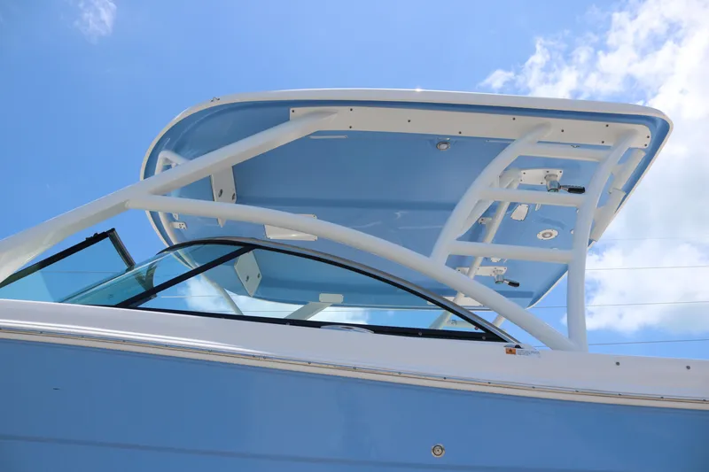 Slide: The Image of 2023 Robalo R317 boat with sleek blue and white design under a clear sky. - 4