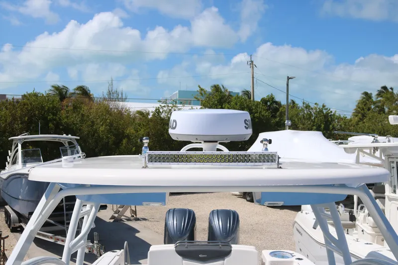 Slide: The Image of 2023 Robalo R317 boat with radar and twin engines, docked under a clear sky. - 6