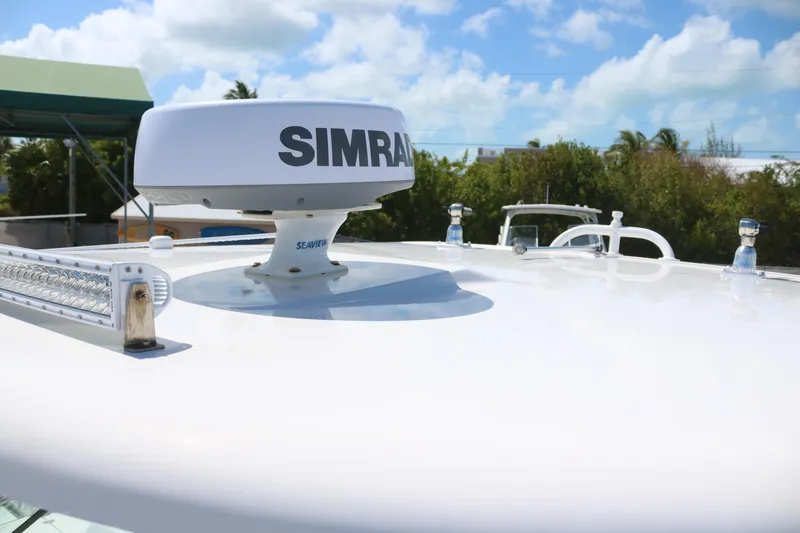 Slide: The Image of 2023 Robalo R317 boat with Simrad radar on deck under blue sky. - 8