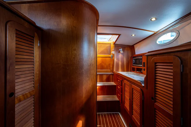 Slide: The Image of Interior of 2017 Hinckley Picnic Boat 37 MKIII with wooden cabinetry and ambient lighting. - 15