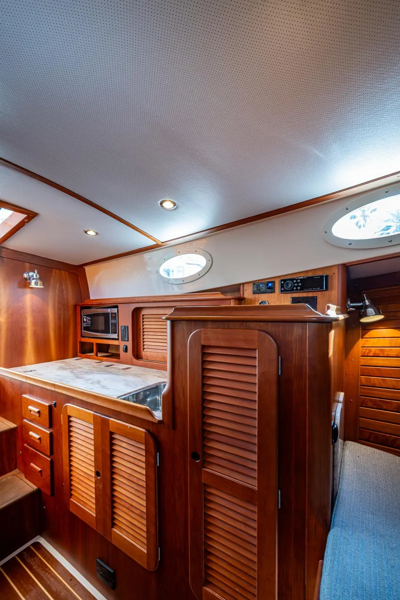 Slide: The Image of 2017 Hinckley Picnic Boat 37 MKIII interior with wood cabinetry and modern amenities. - 16