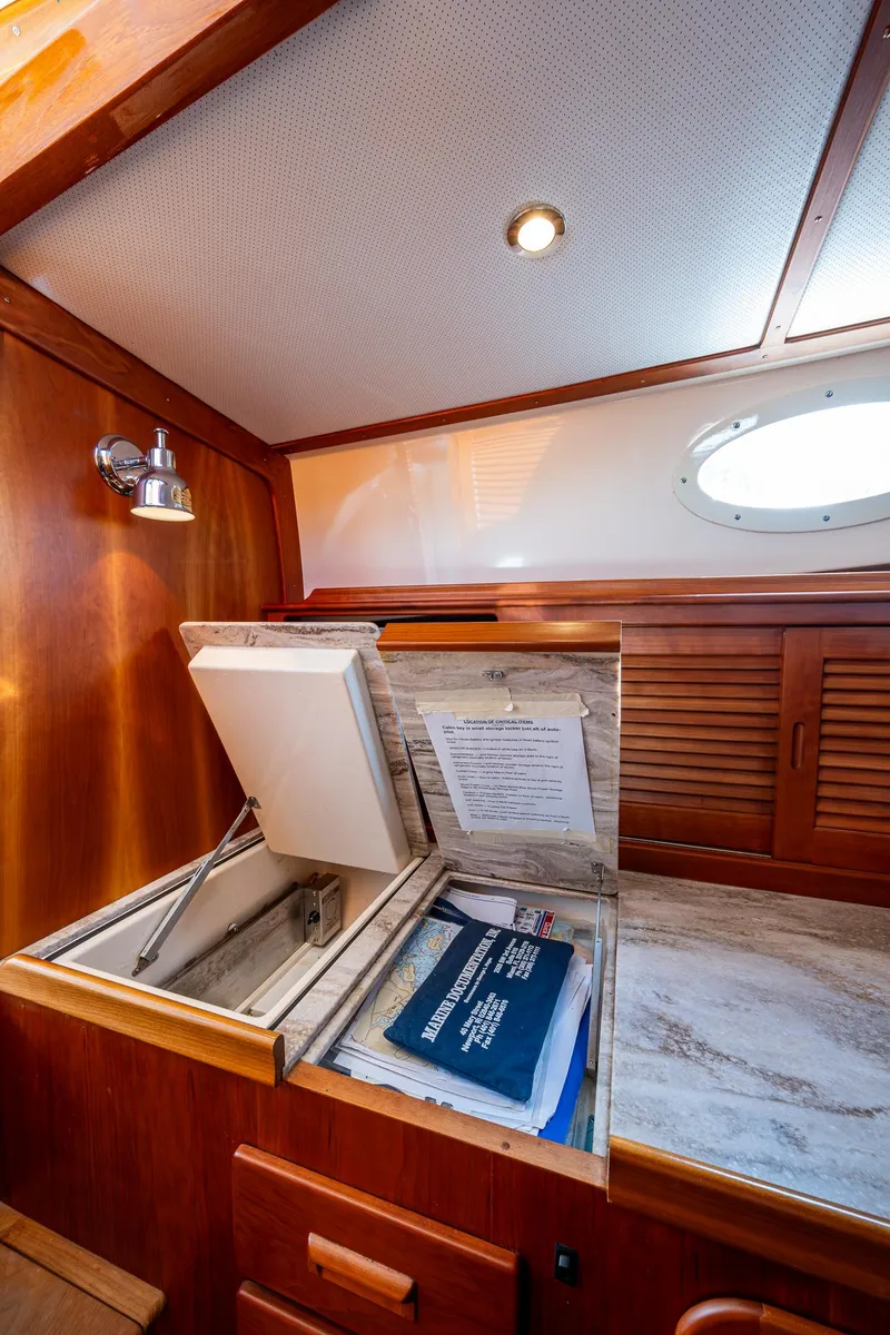 Slide: The Image of 2017 Hinckley Picnic Boat 37 MKIII interior with wooden cabinetry and storage compartment. - 17