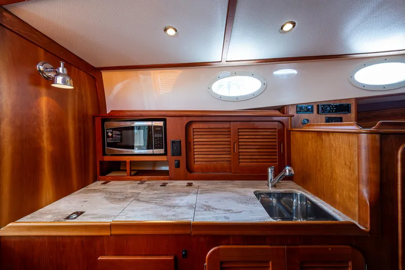 Slide: The Image of 2017 Hinckley Picnic Boat 37 MKIII galley with wood cabinetry and modern appliances. - 18