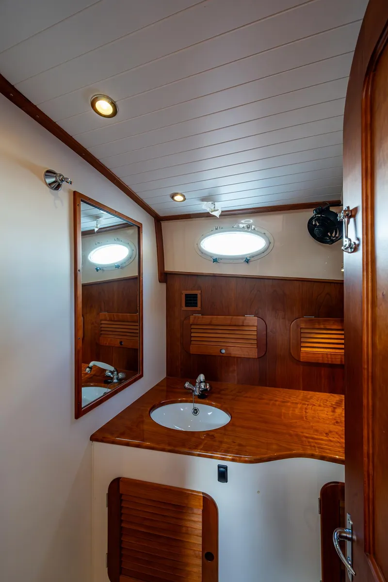 Slide: The Image of 2017 Hinckley Picnic Boat 37 MKIII bathroom with wooden cabinetry and round sink. - 23