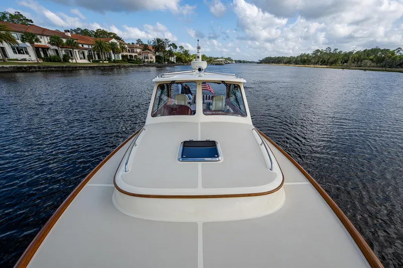 Slide: The Image of 2017 Hinckley Picnic Boat 37 MKIII cruising on a scenic river under a cloudy sky. - 31