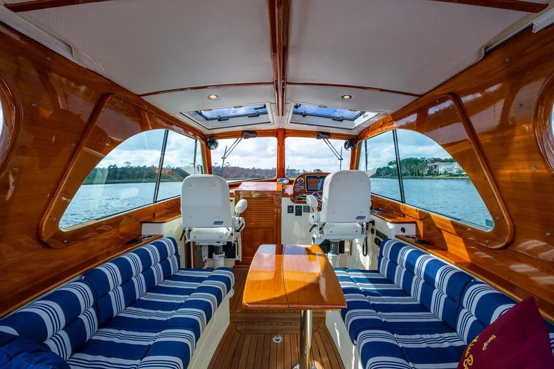 Slide: The Image of Luxurious interior of 2017 Hinckley Picnic Boat 37 MKIII with striped seating and wooden finishes. - 9
