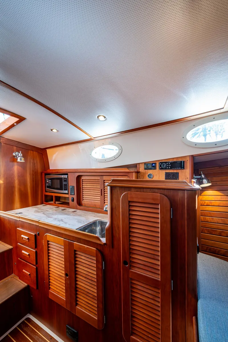 Slide: The Image of 2017 Hinckley Picnic Boat 37 MKIII interior with wood cabinetry and modern amenities. - 19