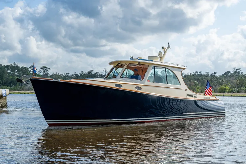 Slide: The Image of 2017 Hinckley Picnic Boat 37 MKIII cruising on a calm river under a cloudy sky. - 32