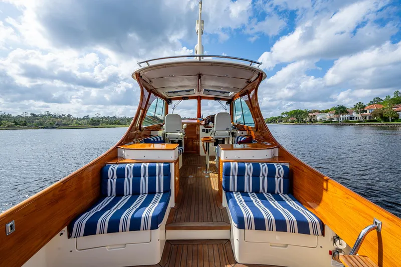 Slide: The Image of 2017 Hinckley Picnic Boat 37 MKIII with striped seating on a serene lake. - 6