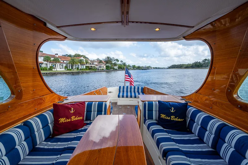 Slide: The Image of Hinckley Picnic Boat 37 MKIII, 2017, luxurious interior with striped seating, scenic waterfront view. - 7