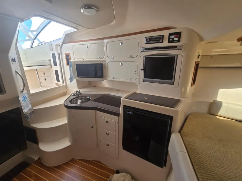Slide: The Image of Interior of a 2005 Grady-White 330 Express boat with kitchenette and seating area. - 11