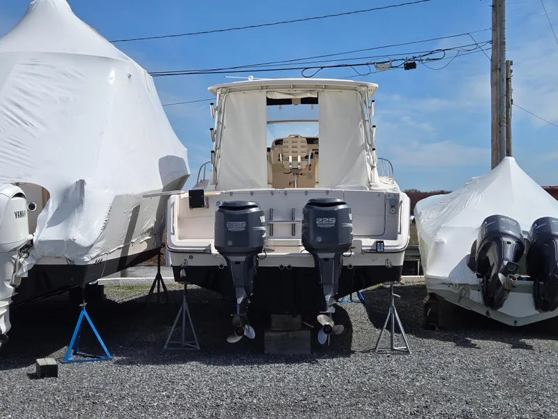 Slide: The Image of 2005 Grady-White 330 Express boat with dual outboard engines, stored outdoors. - 2