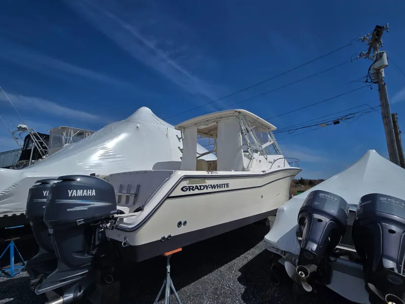 Slide: The Image of 2005 Grady-White 330 Express boat with Yamaha engines, parked outdoors under clear blue sky. - 5