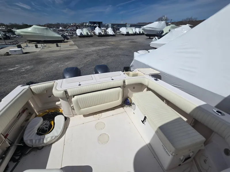 Slide: The Image of 2005 Grady-White 330 Express boat interior with seating, docked among covered boats. - 6