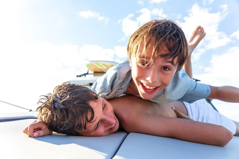 Slide: The Image of Two children playing joyfully on a Jeanneau NC 795 Series 2 boat, 2025 model. - 43