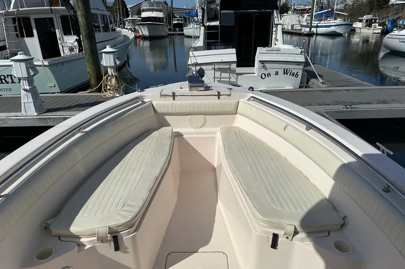 Slide: The Image of 2007 Grady-White 273 CHASE boat interior at marina, featuring cushioned seating and docked vessels. - 8