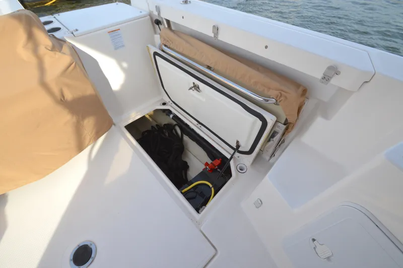 Slide: The Image of 2020 Ranger Tugs R-27 boat storage compartment with open hatch and visible equipment. - 14