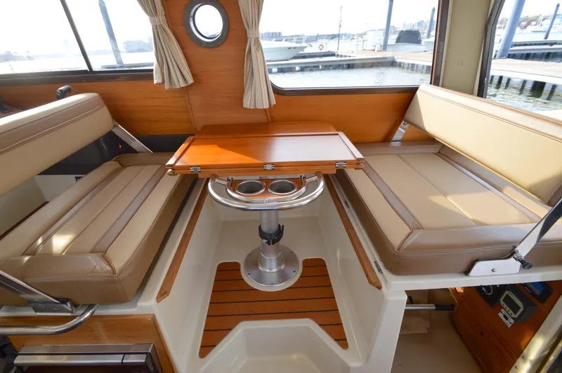Slide: The Image of Interior of 2020 Ranger Tugs R-27 with beige seating and wooden table. - 20