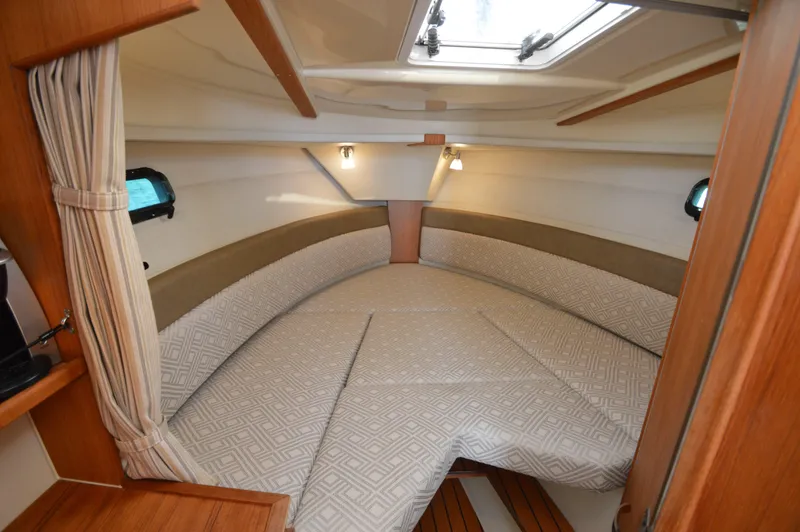 Slide: The Image of 2020 Ranger Tugs R-27 cabin interior with cozy bed and wooden accents. - 23