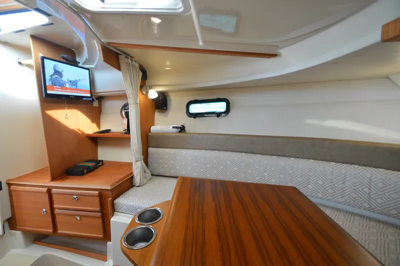 Slide: The Image of Interior of 2020 Ranger Tugs R-27 boat with cozy seating and wooden cabinetry. - 26