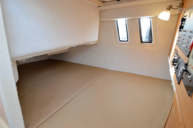 Slide: The Image of 2020 Ranger Tugs R-27 cabin interior with cozy sleeping area and natural light. - 31