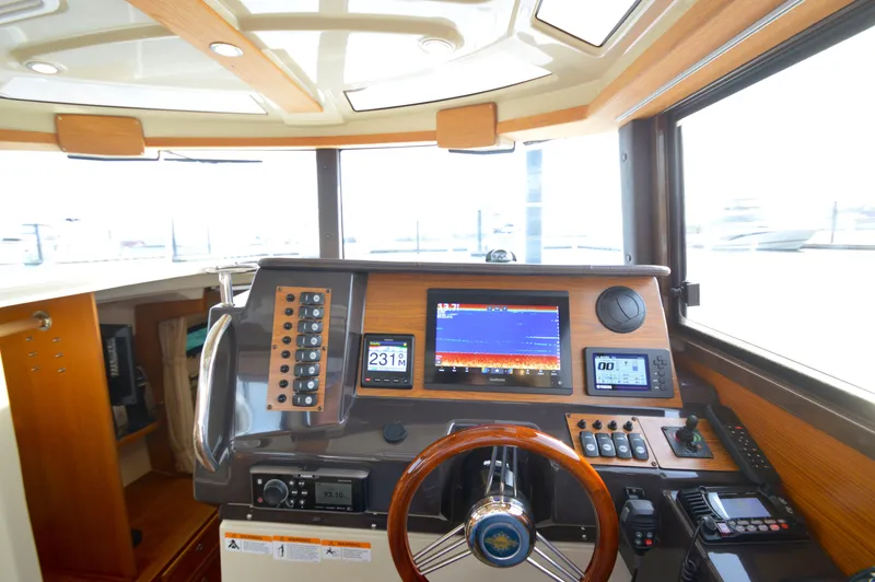 Slide: The Image of 2020 Ranger Tugs R-27 helm with navigation screens and controls. - 33