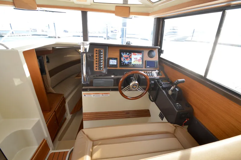 Slide: The Image of 2020 Ranger Tugs R-27 boat interior with helm, navigation controls, and seating. - 34