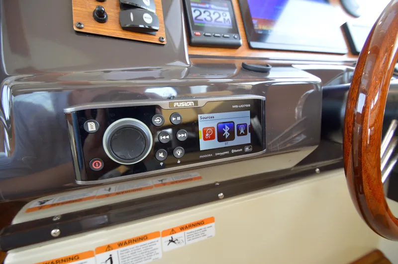 Slide: The Image of 2020 Ranger Tugs R-27 dashboard with Fusion audio system and wooden steering wheel. - 39