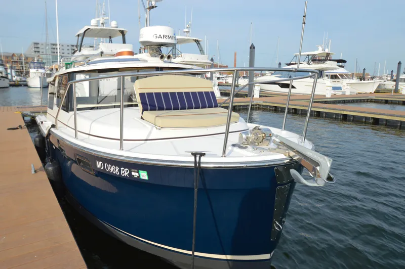 Slide: The Image of 2020 Ranger Tugs R-27 boat docked at marina, featuring blue hull and deck seating. - 8