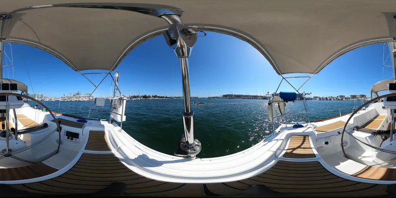 Slide: The Image of 2002 Beneteau First 47.7 sailboat deck with dual steering wheels, under sunny skies. - 14