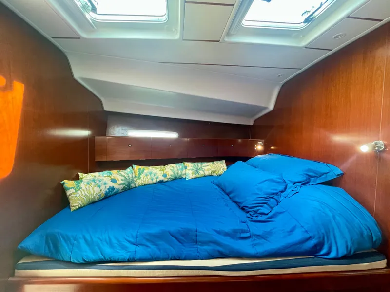 Slide: The Image of Cozy cabin interior of 2002 Beneteau First 47.7 sailboat with blue bedding. - 30