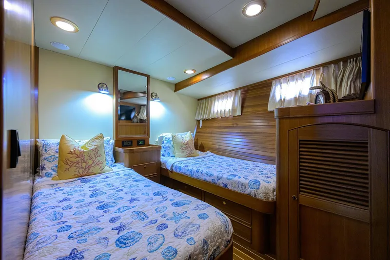 Slide: The Image of Twin cabin interior of 2011 Marlow 97 Explorer yacht, featuring cozy beds and wooden decor. - 46