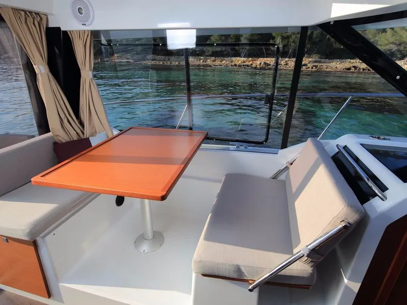 Slide: The Image of Interior of 2024 Jeanneau NC 895 boat with seating and table, overlooking water. - 11